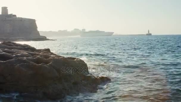 Valletta, Malta 4 luglio 2016 .Vista mare. Panorama di mare e cielo. Nave da carico solitaria in lontananza. Rafforzamento del mare concreto . — Video Stock