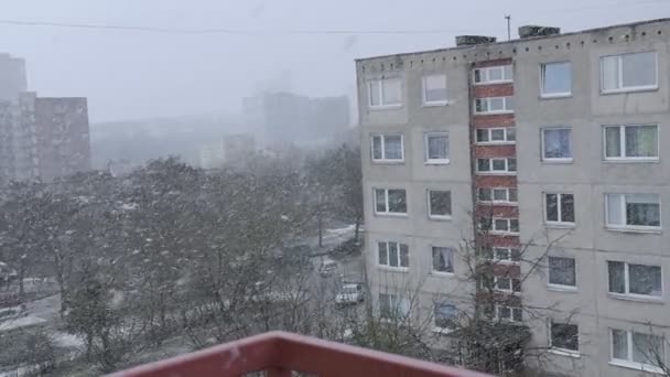 Snö faller framför den levande flervåningshus. Levande flats i vinter. — Stockvideo