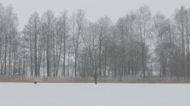 Zimní rybolov. Osamělý rybář sedí na rybaření na ledu. — Stock video