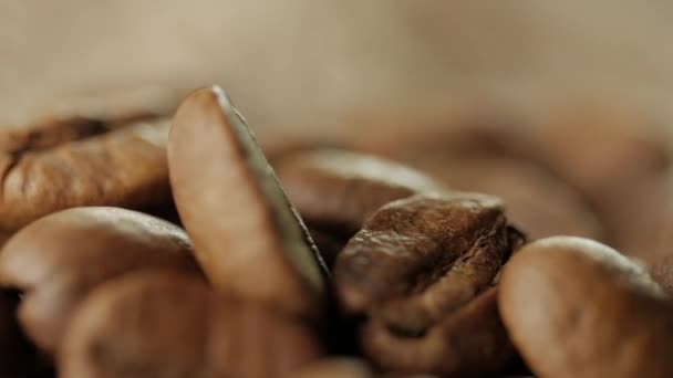 Granos de café tostados giratorios girando sobre la mesa . — Vídeo de stock