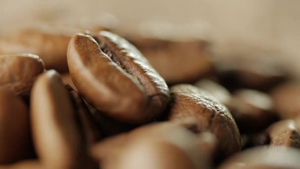 Granos de café tostados giratorios girando sobre la mesa . — Vídeo de stock