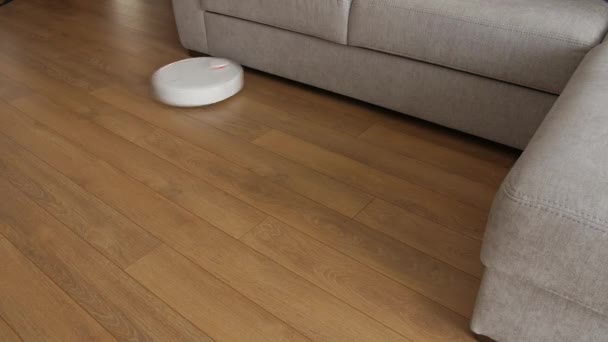 Cleaning technology machine in living room on brown floor. Smart Robot vacuum cleaner. — Stock Video