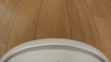 Temizleme teknolojisi makinesi kahverengi katta oturma odasında. Akıllı Robot elektrik süpürgesi.