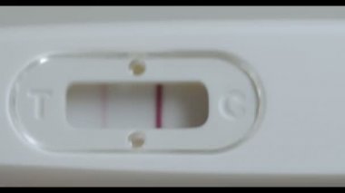 Pozitif gebelik testi elinde. Bir beyaz arka plan makro çekim izole