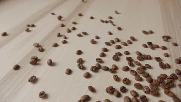 Roasted coffee beans spilling out on wooden plank — Stock Video