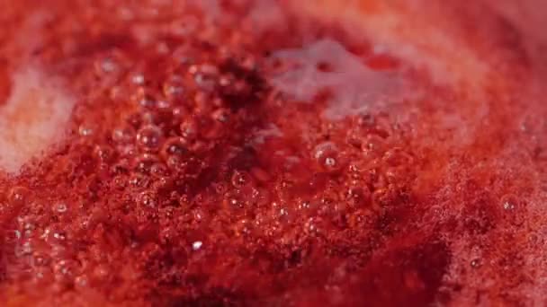 Gros plan du processus d'ébullition des canneberges rouges dans la chaudière pour la confiture .