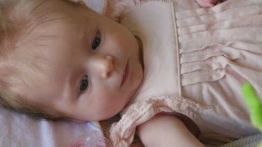 Küçük gülümseyen bir oyuncak bebekle. Mutlu bebek oyuncak asılı ile oynamak.