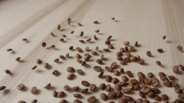 Pražená zrnková káva rozlévá na dřevěné prkno — Stock video