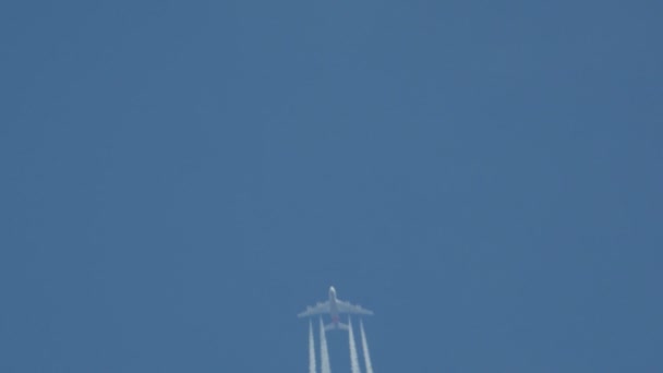 Airplane in flight, making a white stripe in the blue sky, called a contrail, condense trail or vapour trail. — Stock Video