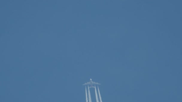 青い空に白のストライプを作る飛行の飛行機は、飛行機雲との呼ばれる、歩道または蒸気トレイルを凝縮. — ストック動画