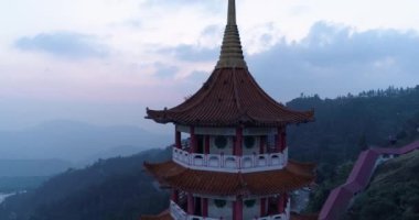 Genting Highlands, Malezya 'daki Chin Sweet Caves Buddha Tapınağı Kulesi' nin sinematik gün batımı görüntüsü. 4k