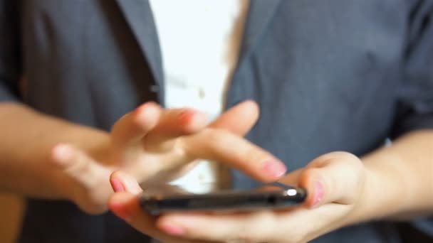 Mains féminines défilant, glissant, tapant, zoomant sur l'écran du smartphone, gros plan 