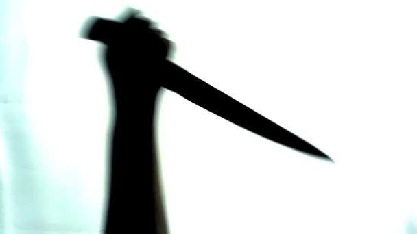 Mano con un cuchillo apuñalando a alguien sobre fondo blanco, thriller, homicidio — Vídeos de Stock