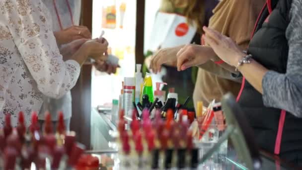 Clients féminins testant de nouveaux produits de beauté dans les grands magasins, cosmétologie — Video