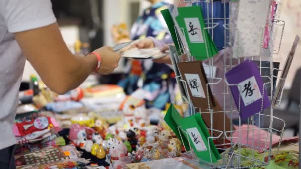 Ιαπωνικά ευχετήριες κάρτες στο περίπτερο, κατάστημα με σουβενίρ, επιλέγοντας ένα δώρο πελάτη — Αρχείο Βίντεο