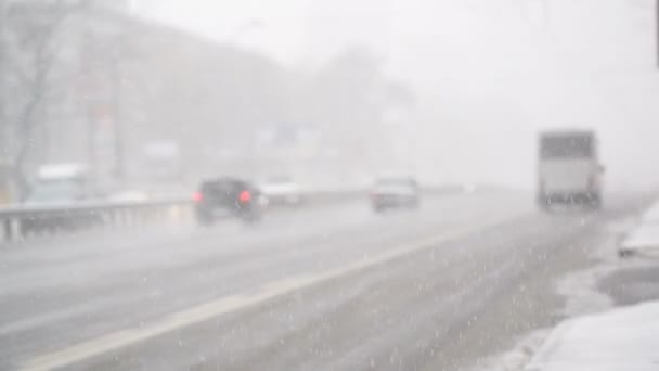 Городское движение во время зимнего снегопада, скользкие дорожные условия, риск аварии — стоковое видео
