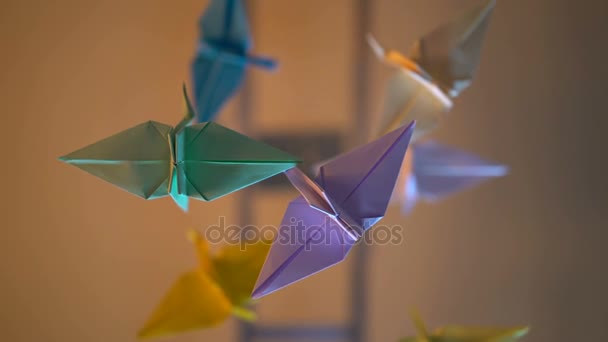 Beautiful origami cranes spinning in the air, bottom view, art, handmade toys — Stock Video