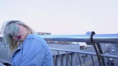 Hip-hop dansçısı kız köprüde müzik yapıyor, iç özgürlüğü gösteriyor.