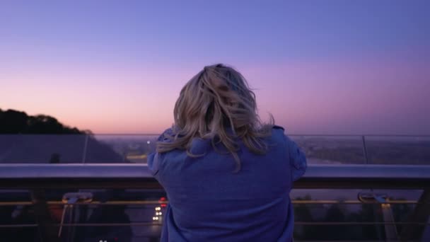 Депрессивная молодая женщина смотрит на ночной городской пейзаж с моста, жизненные проблемы — стоковое видео