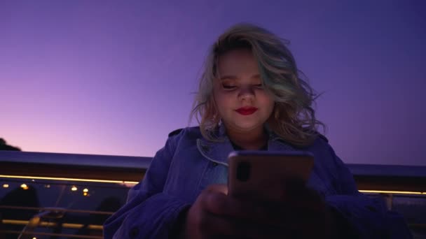 Chica feliz navegando por las redes sociales en gadget en la noche, tecnología de la comunicación — Vídeos de Stock