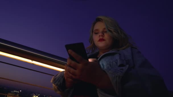 Mujer joven usando la aplicación del teléfono inteligente solo en la ciudad de la noche, problema de adicción gadget — Vídeo de stock