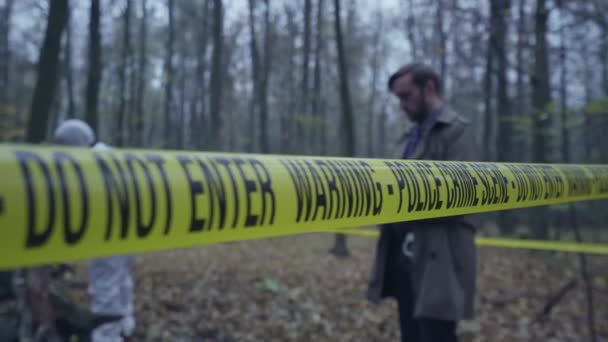 Police detective, forensics team working behind crime scene tape, investigation — Stock Video