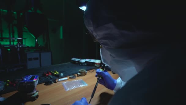 Crazy man making improvised explosive device, soldering in illegal laboratory — Stock Video