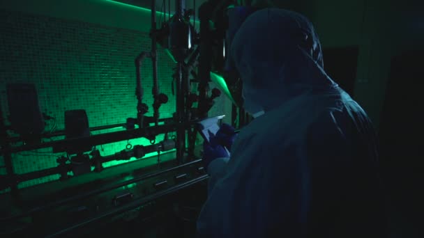 Занятой ученый, работающий в нелегальной лаборатории по производству биологического оружия, пишущий результаты экспериментов — стоковое видео