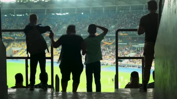 Трое возбужденных подростков смотрят футбол на стадионе, пропустили гол — стоковое видео