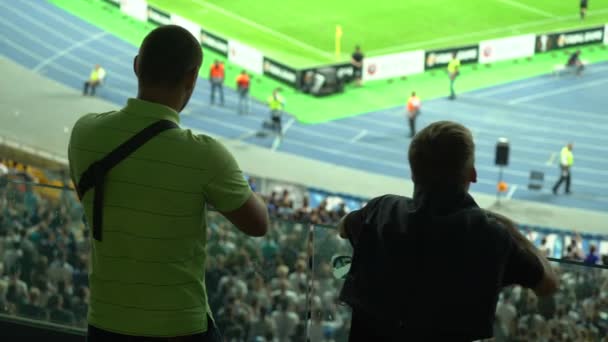 Twee mannelijke vrienden kijken samen voetbal wedstrijd in het stadion, hobby — Stockvideo