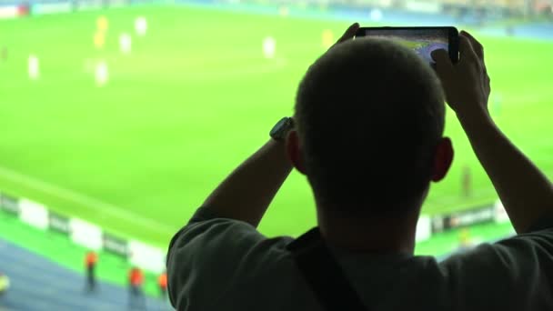 Любитель мужского спорта снимает футбольный матч на смартфон, взволнованный болельщик — стоковое видео
