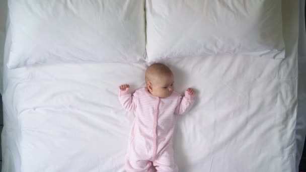 Beautiful newborn baby girl lying on clean white bed linen, allergen-free home — Stock Video