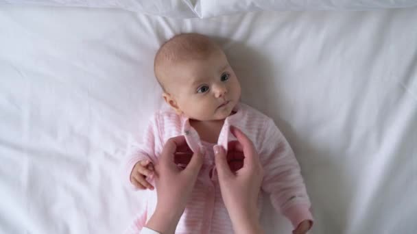 Mãos amorosas mãe vestir bebê recém-nascido ativo, paternidade feliz, cuidados infantis — Vídeo de Stock