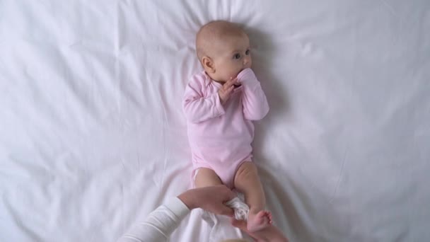 Madre cariñosa vistiendo cuidadosamente a la niña activa, cuidando al niño recién nacido — Vídeo de stock