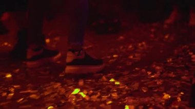 Öğrenci partisinde dans eden gençlerin ayakları, yerde bir sürü konfeti.