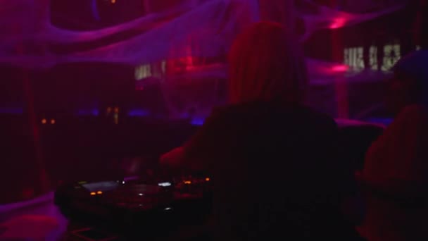 Вдохновлённые женщины-диск-жокеи выступают в ночном клубе, микшируя музыку на проигрывателе — стоковое видео
