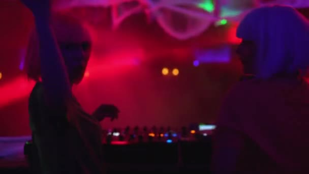 Вдохновлённые диджеи, играющие музыку и танцующие на вечеринке в клубе, позирующие перед камерой — стоковое видео
