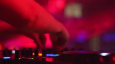 Kadın DJ elleri döner tablonun yakın planında kontrolleri değiştiriyor, müzik performansı