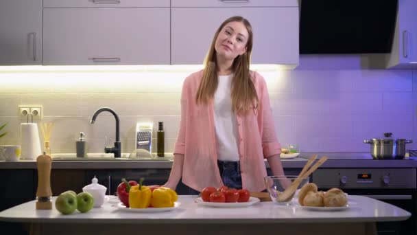 Pretty caucasian female looking at camera, standing near kitchen table, culinary — Stock videók