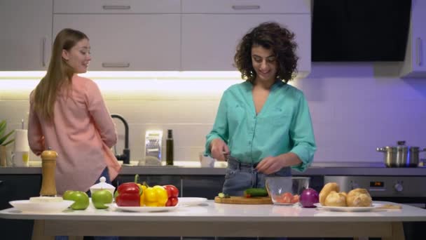 Junge positive Freundinnen reden, zu Hause frischen Salat kochen, gesundes Essen — Stockvideo