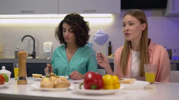 Две сестры разговаривают, обедают вместе за домашним столом, близкие семейные отношения — стоковое видео