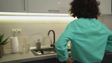 Mutfak lavabosunda bir sürü kirli tabağa bakan hayal kırıklığına uğramış kadın, hizmetçi.