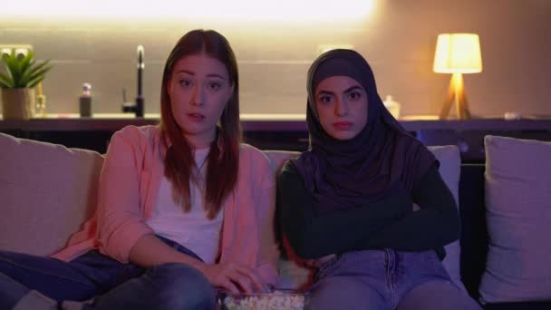 Gespannen meisjes kijken thriller film en het eten van popcorn thuis, ip televisie — Stockvideo