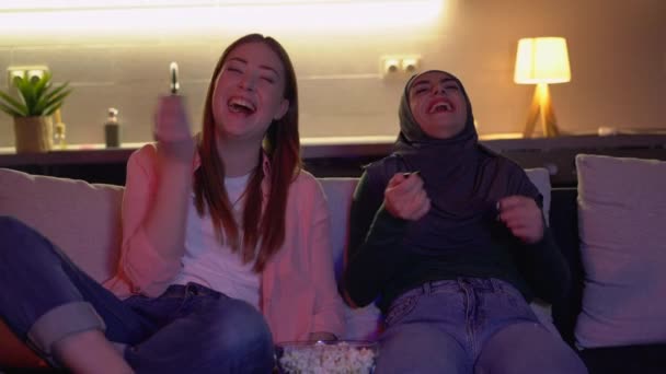 Multiculturele vrienden kijken comedy show op tv, lachen om grap samen — Stockvideo