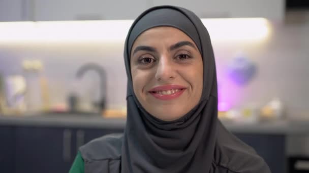 Красивая молодая женщина в хиджабе улыбается в камеру, готовая сломать стереотипы — стоковое видео