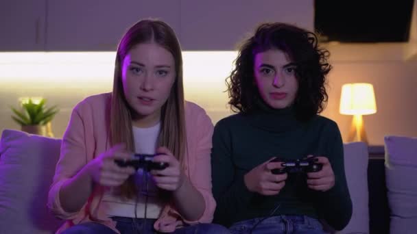 Женщины-друзья играют в видеоигры с джойстиками, эмоциями победы и проигрыша — стоковое видео
