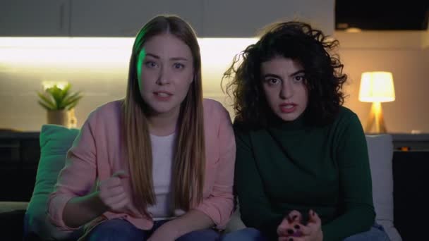 Zwei Mädchen unterstützen Fußballmannschaft, sehen Spiel zu Hause im Fernsehen, enttäuscht — Stockvideo