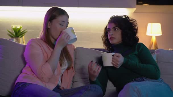 Kvinnliga par med koppar varm dryck talar i mysig atmosfär romantisk dag — Stockvideo