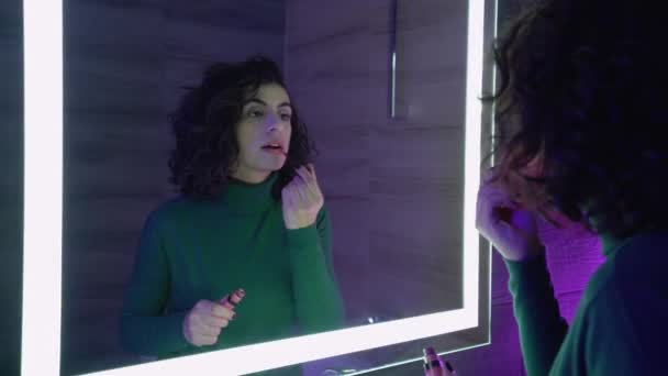 Atractiva joven aplicación de brillo de labios en el espejo del baño delantero, maquillaje diario — Vídeos de Stock