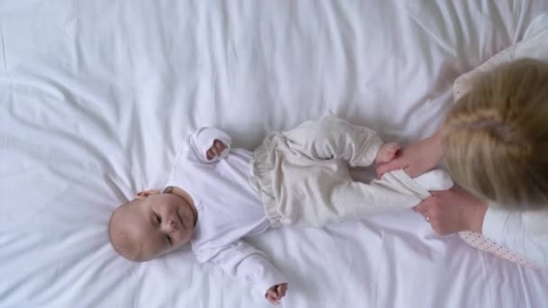 婴儿保育员小心翼翼地给新生婴儿穿上柔软的棉衣、爱心和关怀 — 图库视频影像